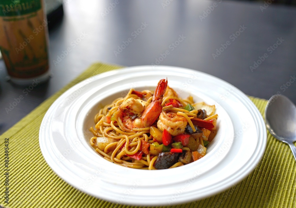 Spaghetti with Thai Spicy Herbal Sauce and prawns on white plate