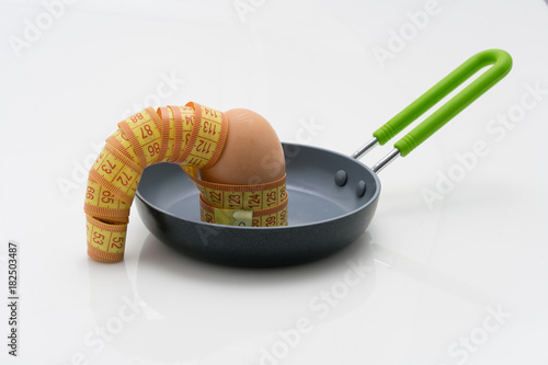 Measurement Tape on Egg in a Fry Pan, concept of healthy food and diet
