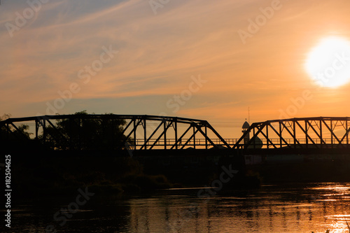 silhouette railway bridge and reflex in river before sunrise in the morning with copy space add text