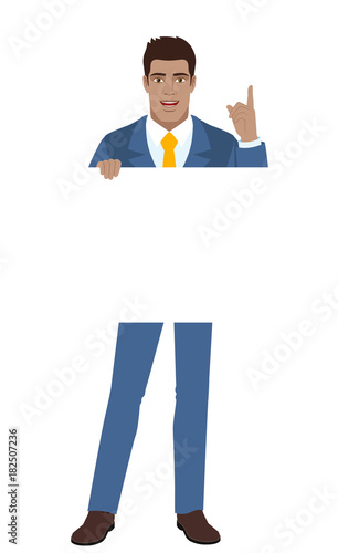 Businessman holding white blank poster and pointing up