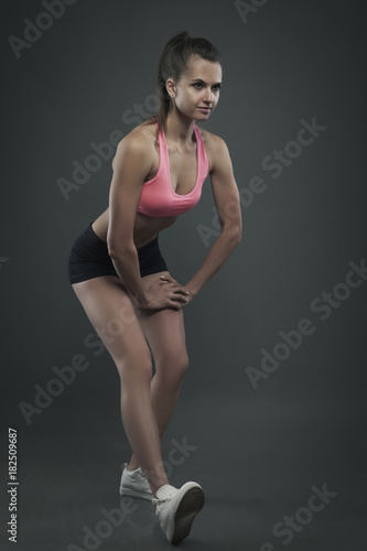 Woman standing in sport pose studio shot dark bg