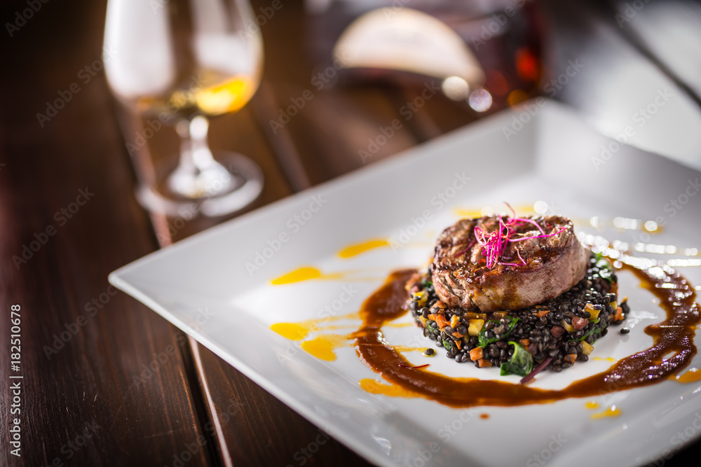 Beef Steak. Grill beef steak black lentils mixed with vegetable. Cognac or brandy as drink. Culinary food in hotel pub or restaurant Beef Steak. Grill beef steak black lentils mixed with vegetable. Cognac or brandy as drink. Culinary food in hotel pub or restaurant
