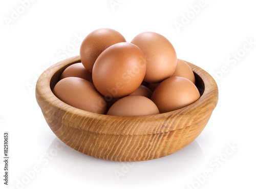 Wooden bowl with eggs isolated on white background.
