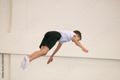 the young man performs gymnastic exercises in the gym.