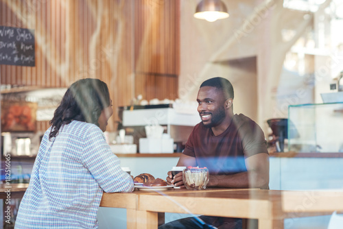 Young African couple talking together over coffee in a cafe