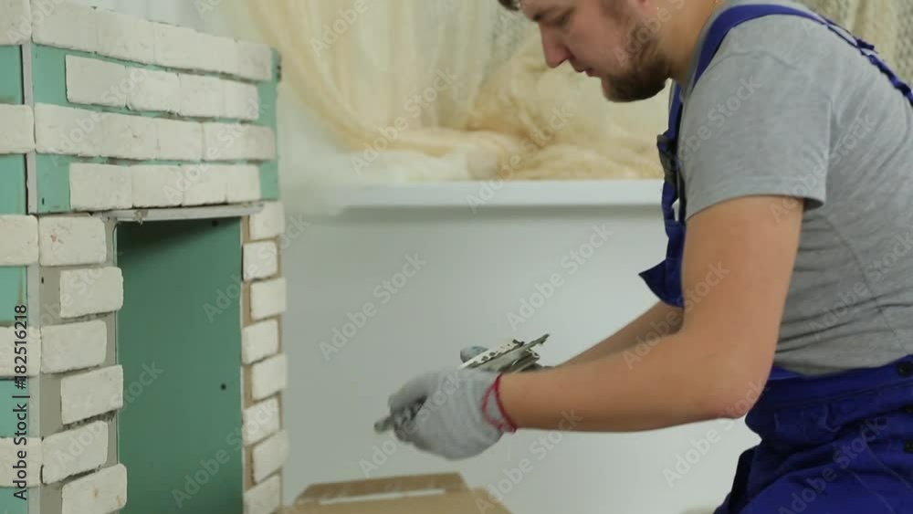 man makes repairs, lays tile man makes repairs, lays tile