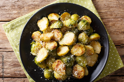 roasted brussels sprouts with garlic and Parmesan cheese on a plate close-up. horizontal top view