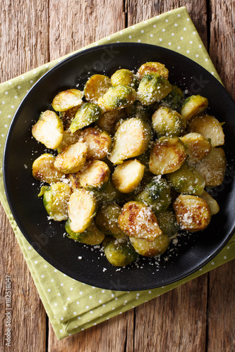 roasted brussels sprouts with garlic and Parmesan cheese on a plate close-up. Vertical top view