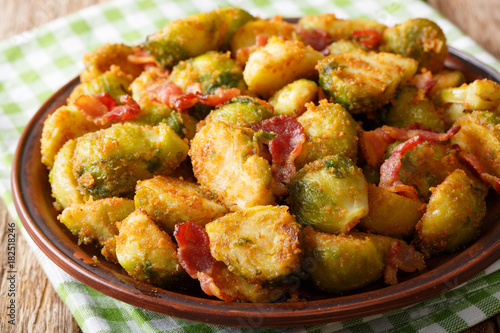 Delicious fried Brussels sprouts with crispy bacon close-up on a plate. horizontal