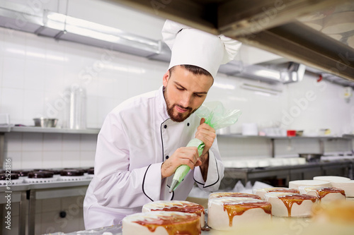 Foto The confectioner is preparing a cake in the kitchen of the pastry shop