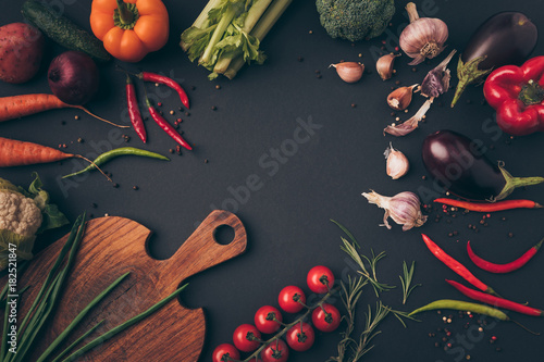 top view of different vegetables and cutting board on a table