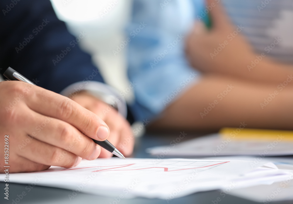Businessman signing document in office Businessman signing document in office