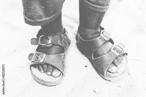 Crop child in sandals on sand photo