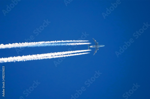Airplane big four engines aviation airport contrail clouds. © aapsky