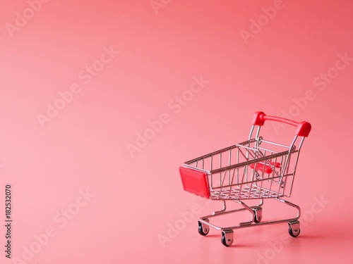 Close up shopping cart over pink background,copy space.