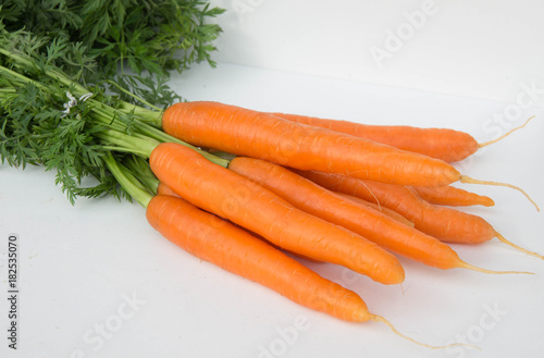 France, Rhone/Alps, Ferney Voltaire, November 2017: Bunch of young carrots with green leaves on white background photo