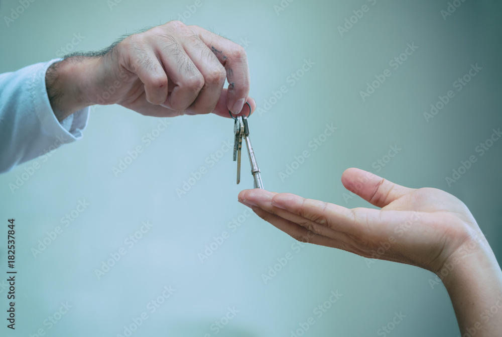 Close up of realtor hand giving house key to owner home, buying selling property business. Close up of realtor hand giving house key to owner home, buying selling property business.