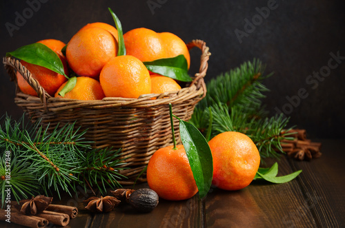 Fresh tangerine clementines with spices on dark wooden background, Christmas concept.