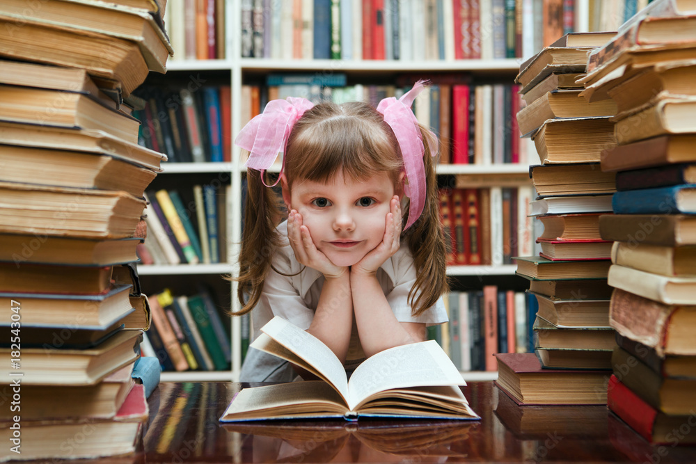 preschooler little girl reading a book in the library
preschooler little girl reading a book in the library