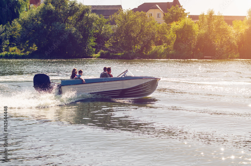Fototapeta premium Motor boat with people floating on the river