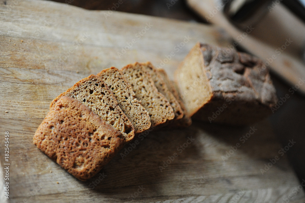 Fresh homemade unleavened bread on the leaven is sliced on a wooden board. Serving of breakfast Fresh homemade unleavened bread on the leaven is sliced on a wooden board. Serving of breakfast