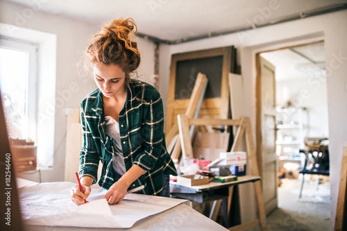 Young woman drawing at table in workshop photo