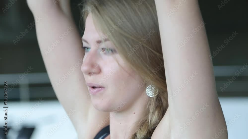 A young woman performs exercises at the gym. A young girl is engaged in fitness. Girl doing exercises with dumbbell. A young woman performs exercises at the gym. A young girl is engaged in fitness. Girl doing exercises with dumbbell.