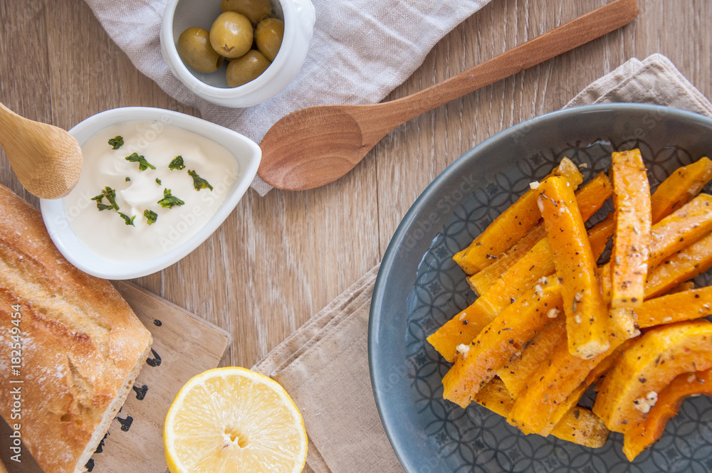 Snack. Pumpkin pieces baked in spices on a plate with cream sauce Snack. Pumpkin pieces baked in spices on a plate with cream sauce