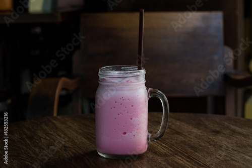 Beverage, pink milk. Cold sweet of pink milk in glass, delicious drink on vintage of wooden table set. Asia local drink.