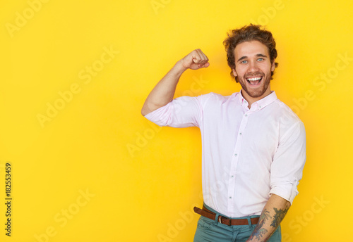 Cheerful man showing bicep Fototapet