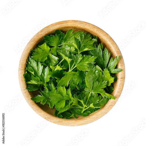 Fresh parsley leaves in a wooden bowl isolated on white. Top view.