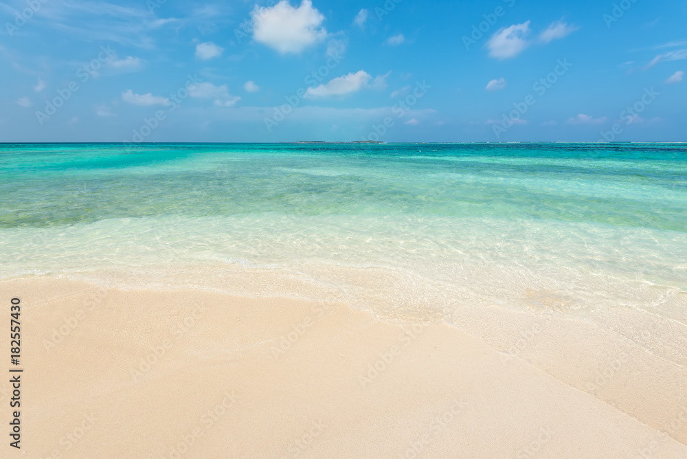 Empty tropical beach background. Horizon with resort island, sky and white sand in Maldives.