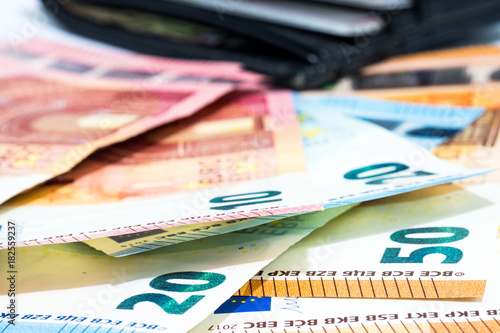 Pile of various kinds euro banknotes with black leather wallet use for money or currency background and financial concepts.