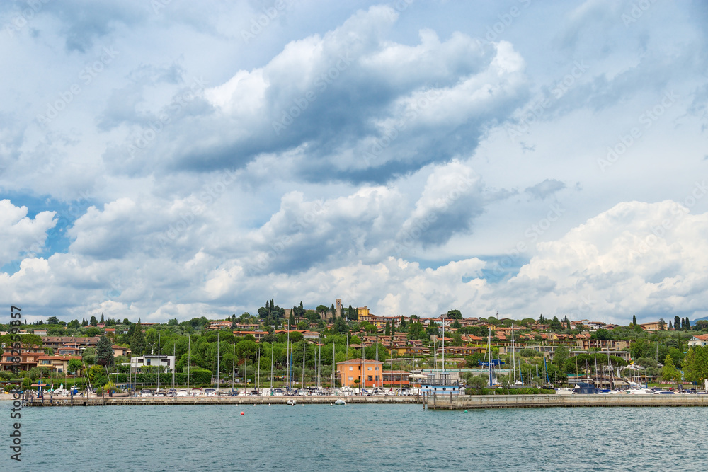 The view from the water on the coast of the small Italian town of Manerba del Garda. Natural scenery of Lake Garda.