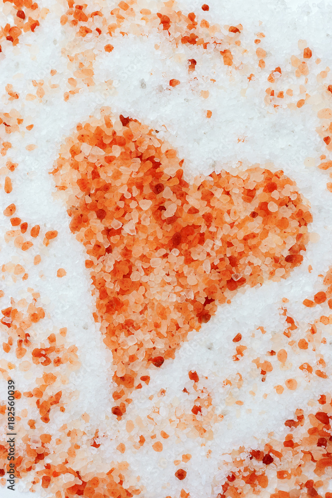 The figure of the heart is lined with sea salt, yellow, red, brown shades on a light background. The background of the large crystals of sea salt for Valentine's day or salon Spa The figure of the heart is lined with sea salt, yellow, red, brown shades on a light background. The background of the large crystals of sea salt for Valentine's day or salon Spa