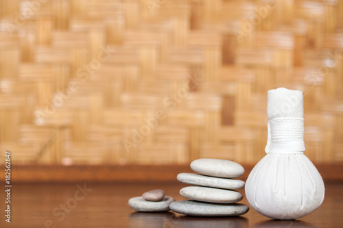 Herbal compress on wooden table, spa and wellness concept