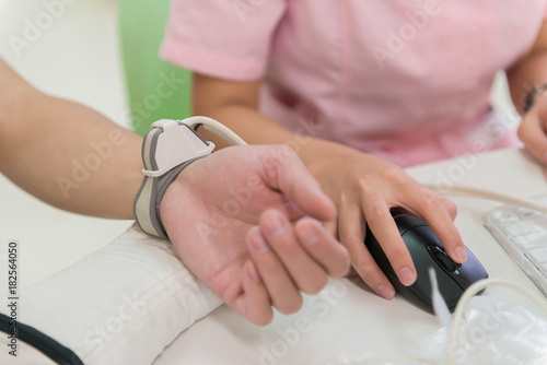 nurse using medical facility checking pulse and blood pressure etc for a man