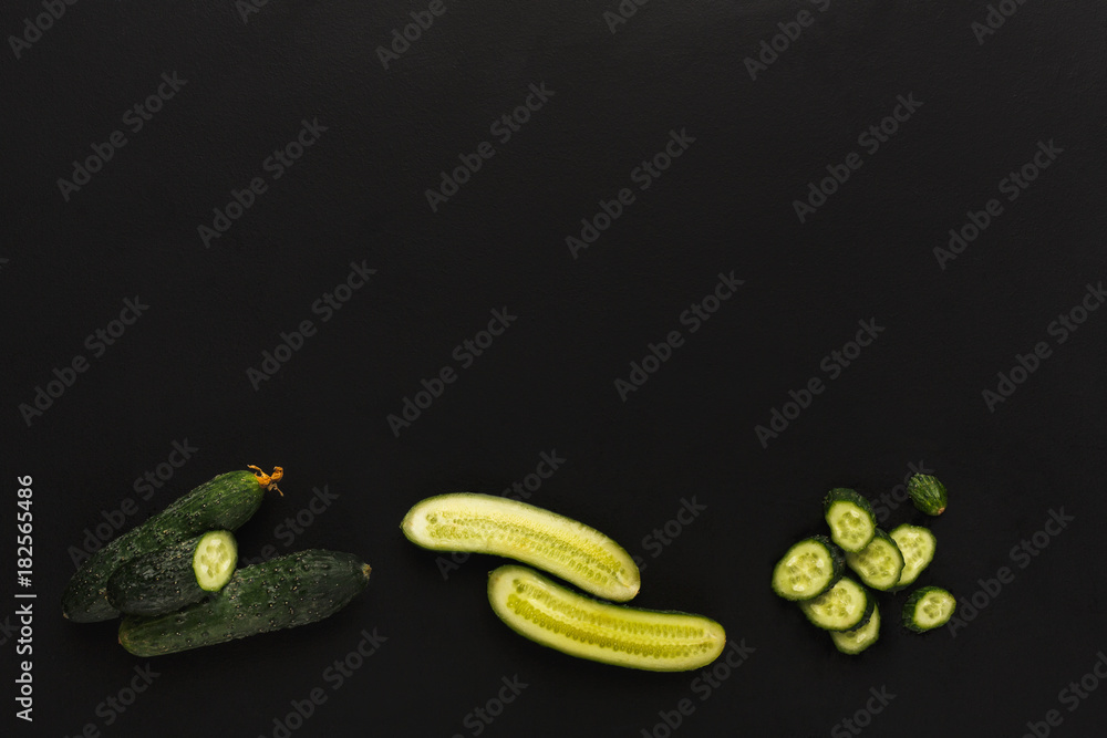 Whole and cut cucumber on black isolated background Whole and cut cucumber on black isolated background