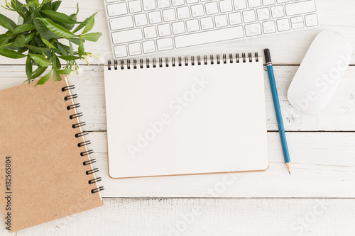 Flat lay photo of office desk with mouse and keyboard,Empty open notebook on white wood table top view