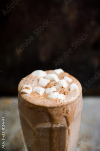 Hot chocolate with marshmallow on the wooden background. Shallow depth of field. Toned image.