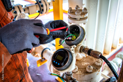 Fotografija Hand of technician,Instrument technician on the job calibrate or function check level transmitter in oil and gas process
