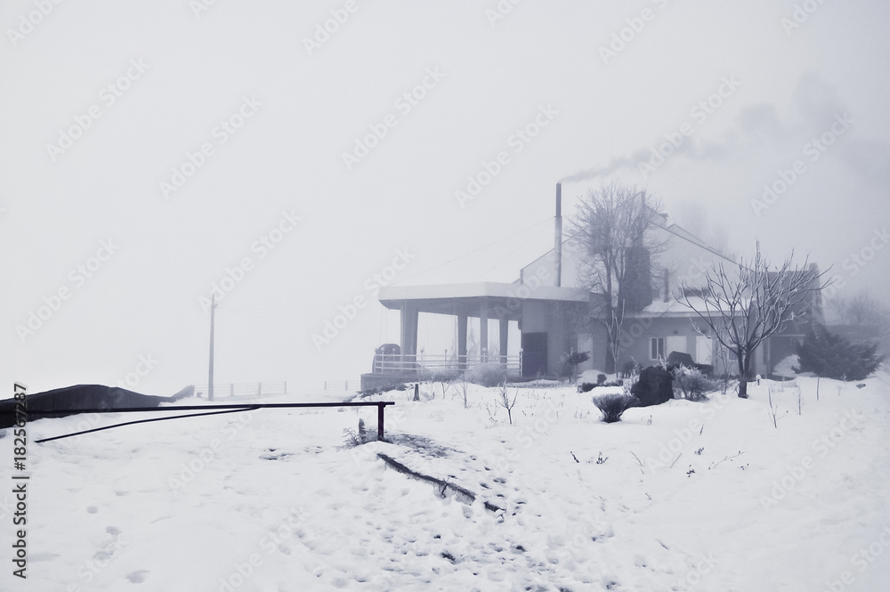 Smoke from the chimney of the house raises the mood in the bad weather of the winter blizzard Smoke from the chimney of the house raises the mood in the bad weather of the winter blizzard