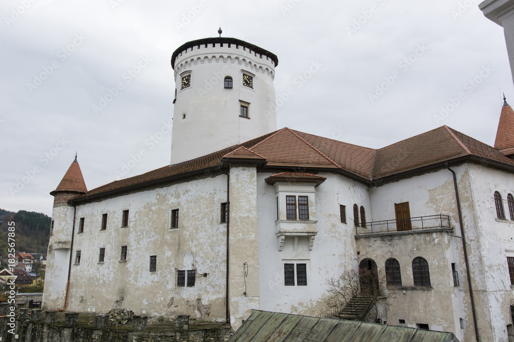Old castle with fading plaster and tower.