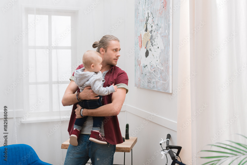 dad holding his little son on hands at home dad holding his little son on hands at home