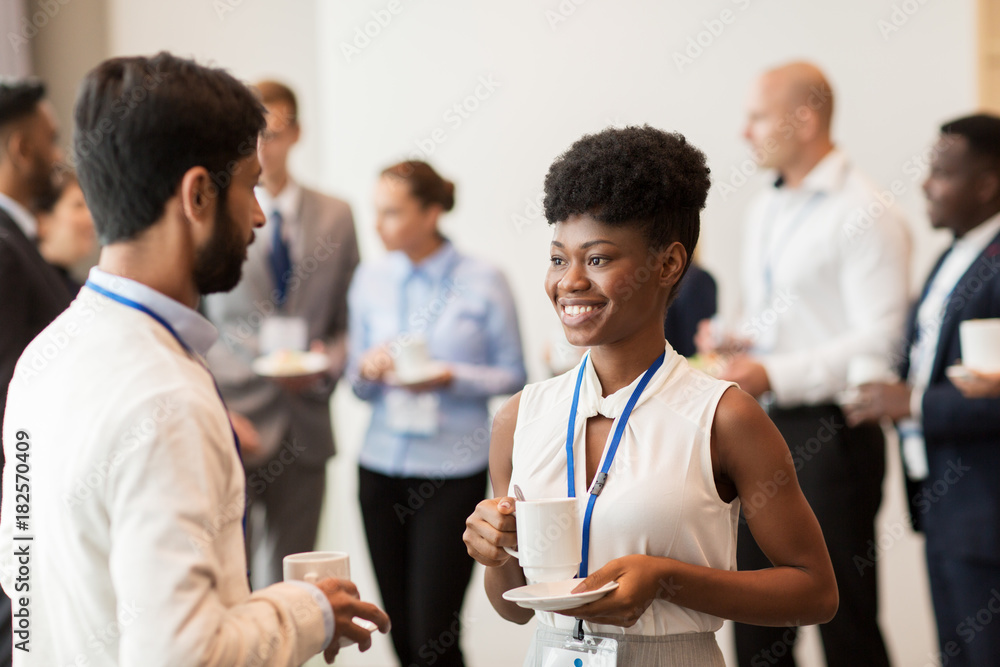 © Syda Productions - business people with conference badges and coffee