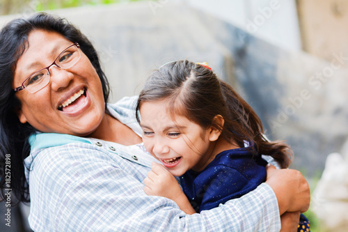 Happy latin and little daughter outside.