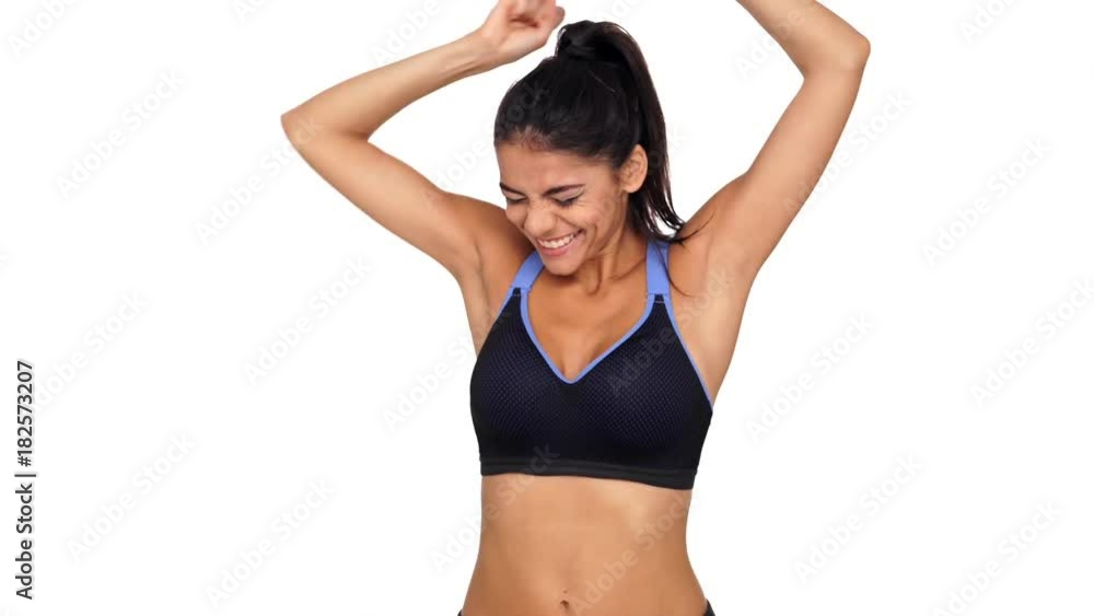So happy brunette fitness woman rejoice and jumping while looking at the camera over white background So happy brunette fitness woman rejoice and jumping while looking at the camera over white background