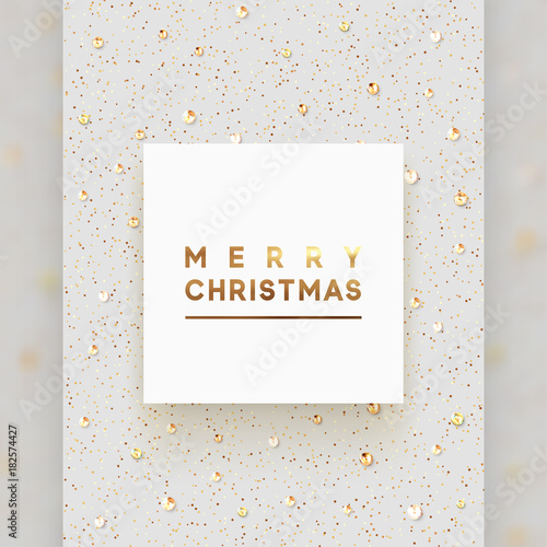 Christmas background is strewn with precious stones and bright sparkles. Merry Christmas lettering in square white frame, luxury text of gold color.