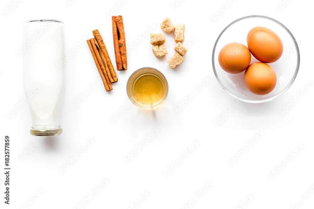 Ingredients for eggnog. Eggs, milk, cinnamon, whiskey on white background top view copyspace