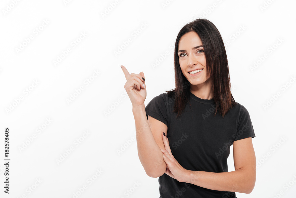 Portrait of a happy young woman pointing finger away Portrait of a happy young woman pointing finger away